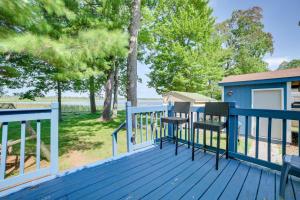 a deck with two chairs and a blue railing at East Tawas Lakefront Getaway with Kayaks and Deck in East Tawas