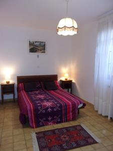 a bedroom with a bed and a chandelier at Location Laroque Cévennes in Laroque