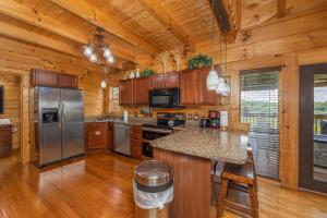 a kitchen with wooden cabinets and a stainless steel refrigerator at Smokies Serenity by American Patriot Getaways in Union Grove