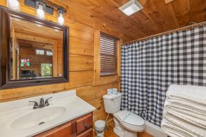 a bathroom with a sink and a toilet and a mirror at Smokies Serenity by American Patriot Getaways in Union Grove +32 photos