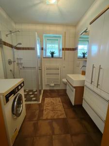 a bathroom with a shower sink and a washing machine at Ferienwohnung Regau 