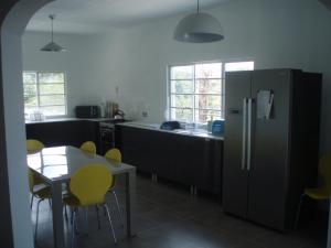 eine Küche mit einem Kühlschrank sowie einem Tisch und Stühlen in der Unterkunft Big Red's in Bull Savanna