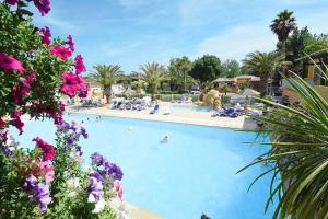 une grande piscine avec des gens dans un complexe hôtelier dans l'établissement Camping Vias-Plage, à Vias 5 autres photos