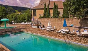 una gran piscina con sillas, mesas y sombrillas en Soaring Heights by American Patriot Getaways, en Chalet Village
