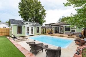 een achtertuin met een zwembad en een huis bij Riverside Bungalow in Nashville