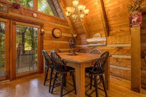 Un comedor con mesa y sillas de madera. en Soaring Heights by American Patriot Getaways, en Chalet Village