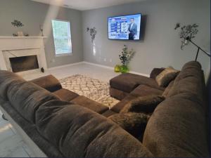 sala de estar con sofá grande y TV en Stone Mountain Escape 4Bedroom Private Home, en Stone Mountain
