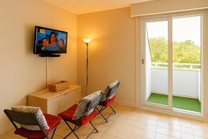 a living room with two chairs and a flat screen tv at Cocon neuf entre mer et campagne 4Pers Parking privé in Villers-sur-Mer