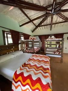 a bedroom with two bunk beds with a striped blanket at Paraiso brisas de la naturaleza in Tona
