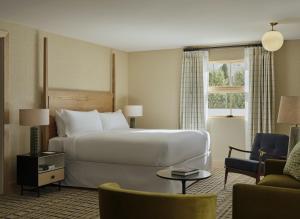 a hotel room with a large bed and a chair at Belden House & Mews in Litchfield