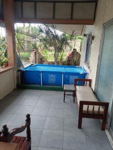 a patio with two benches and a swimming pool at Dhenish's Transient House in Pagbilao