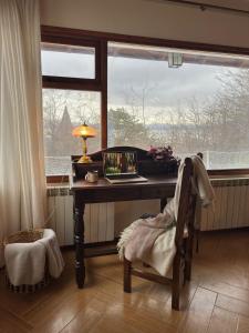 Un escritorio con una computadora portátil frente a una ventana. en CASA WAIA ULU, en Ushuaia
