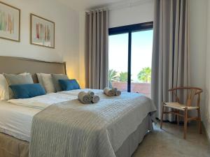 a bedroom with a bed with two stuffed animals on it at Seaview Apartment - COTO REAL Duquesa in Manilva +45 photos