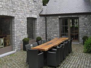 einen Holztisch und Stühle vor einem Gebäude in der Unterkunft Spacious Place in Hamoir in Hamoir