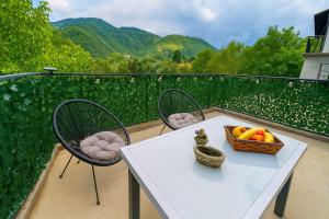 a table and chairs with a basket of fruit on a balcony at River`s Song Cottage Jajce in Jajce