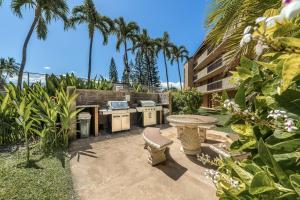 a backyard with a grill and a table and a table sidx sidx sidx at Maui Vista 2422 in Kihei