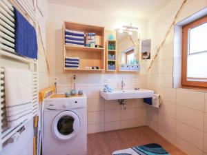 a bathroom with a washing machine and a sink at Holiday home in Taxenbach in Taxenbach