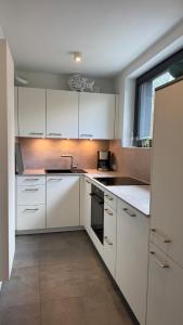 a white kitchen with white cabinets and a window at FeWo im Vest in Oer-Erkenschwick