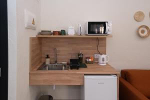 a kitchen with a sink and a microwave at Xaloc Habitaciones in Santa Pola +46 photos