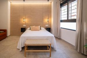 a bedroom with a bed and a table and a window at Xaloc Habitaciones in Santa Pola