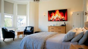 a bedroom with a bed with a fire painting on the wall at Braidmead House in Irvine