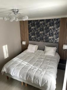 a bedroom with a large bed with a floral wallpaper at Grand 2 pièces ensoleillé in Font-Romeu