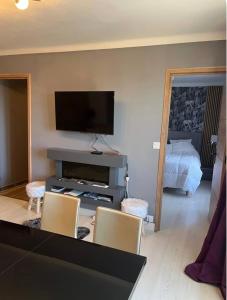 a living room with two chairs and a flat screen tv at Grand 2 pièces ensoleillé in Font-Romeu