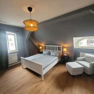 a bedroom with a white bed and a couch at Kutscherhaus mit 2 Schlafzimmer im Zentrum von Senftenberg in Senftenberg