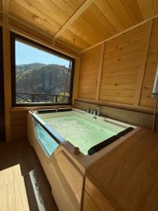 a large bath tub in a room with a window at Mountain house Potkovica in Lazići