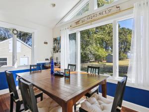 a dining room with a wooden table and chairs and a large window at Crepe Myrtle in Tilghman