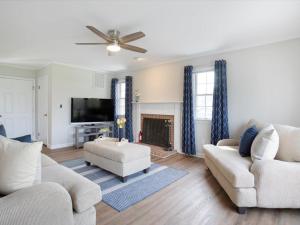 a living room with two couches and a tv at Down By The Docks in Oxford