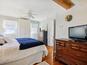 a bedroom with a bed and a flat screen tv at Crepe Myrtle in Tilghman