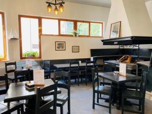 a restaurant with tables and chairs and a piano at Comune Rustico Sport Hotel in Arta Terme