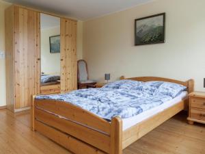 a bedroom with a wooden bed and a mirror at Villa Hochwald Familienhaus in Geisfeld