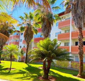 a group of palm trees in front of a building at PONTAL DO LAGO FLAT - Lucas in Caldas Novas