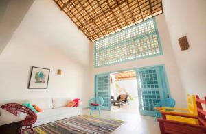a living room with a white couch and a large window at Casa encantadora com Vista Mar na Caponga in Cascavel