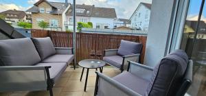 a balcony with two chairs and a table with wine glasses at Ferienwohnung Belle in Andernach