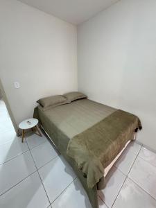 a small bedroom with a bed and a table at Apartamento no centro! Próximo a tudo! in Barreiras