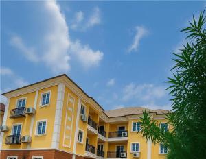a yellow building with balconies on the side of it at 154 Apartments and Hotel in Abuja