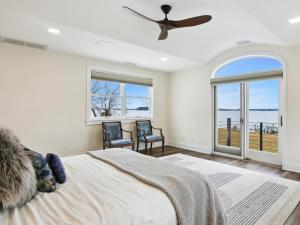 a bedroom with a bed with two chairs and a ceiling fan at Mill Point in Neavitt +59 photos