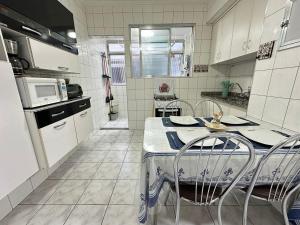 a kitchen with a table and chairs in it at Apto 1 dorm no Canto do Forte - Próximo a Praia! in Praia Grande