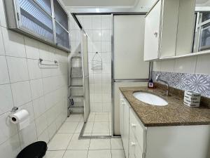 a small bathroom with a sink and a shower at Apto 1 dorm no Canto do Forte - Próximo a Praia! in Praia Grande