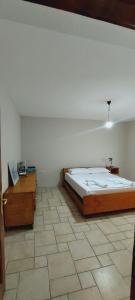 Dinamo Bed&Breakfast في إلباسان: غرفة نوم بها سرير كبير وطاولتين خشبيتين