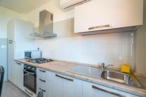 una cocina con fregadero y estufa en Babyaccommodation Family Hills II, en Tovo San Giacomo 40 fotos más