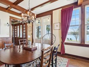 a dining room with a table and chairs and windows at The Water House in Saint Michaels