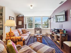 a living room with couches and a tv at The Water House in Saint Michaels