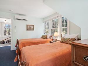 two beds in a room with two windows at The Water House in Saint Michaels