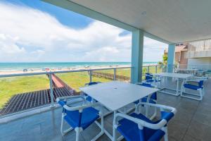 a balcony with tables and chairs and the beach at 5 BEDROOM BEACHFRONT CONDO - 2nd Floor in South Padre Island +31 photos