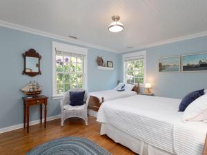 a bedroom with two beds and a chair and two windows at Wakes End in Easton +70 photos