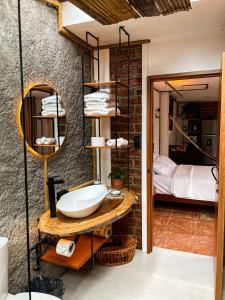 a bathroom with a sink and a bed in a room at Raíces y Refugio in Puyo